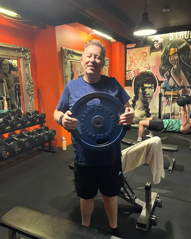 A member with a weight plate by the bench