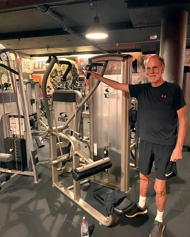 A member smiling by the cable machine