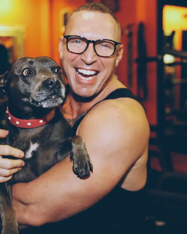 A LiFT member hugging Coco the gym dog