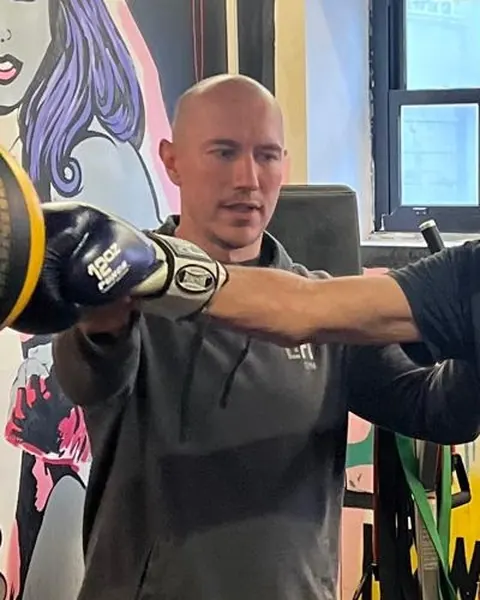 Jozef Maruniak holding boxing pads for a client