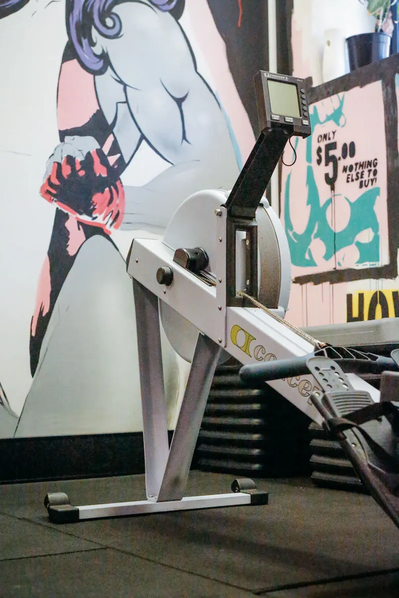 Rowing machine beside a comic-style mural