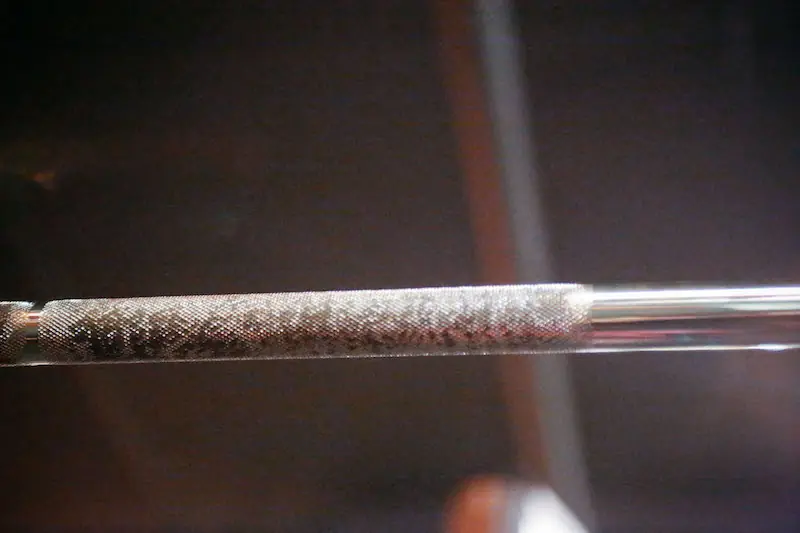 Close-up of a barbell’s knurled grip