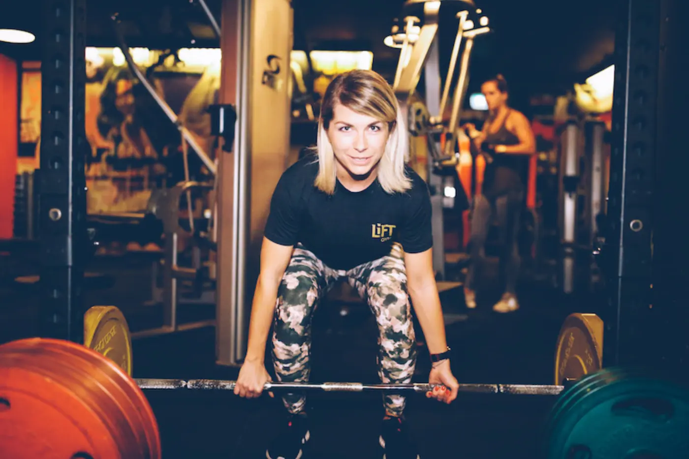 A member smiling as she sets up for a deadlift