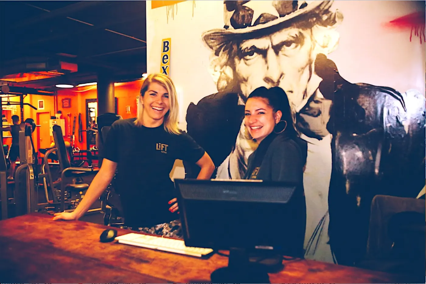 Two members of the LiFT team smiling at the front desk