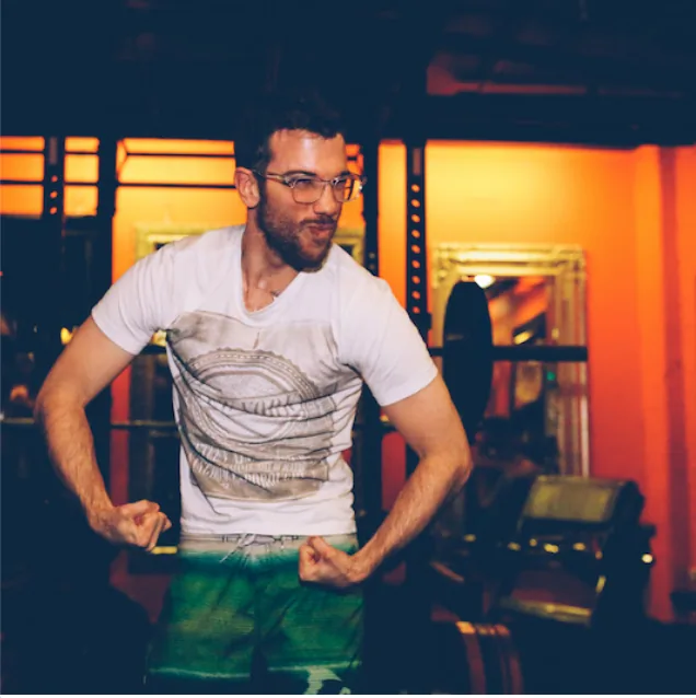 A LiFT member flexing in front of the orange wall